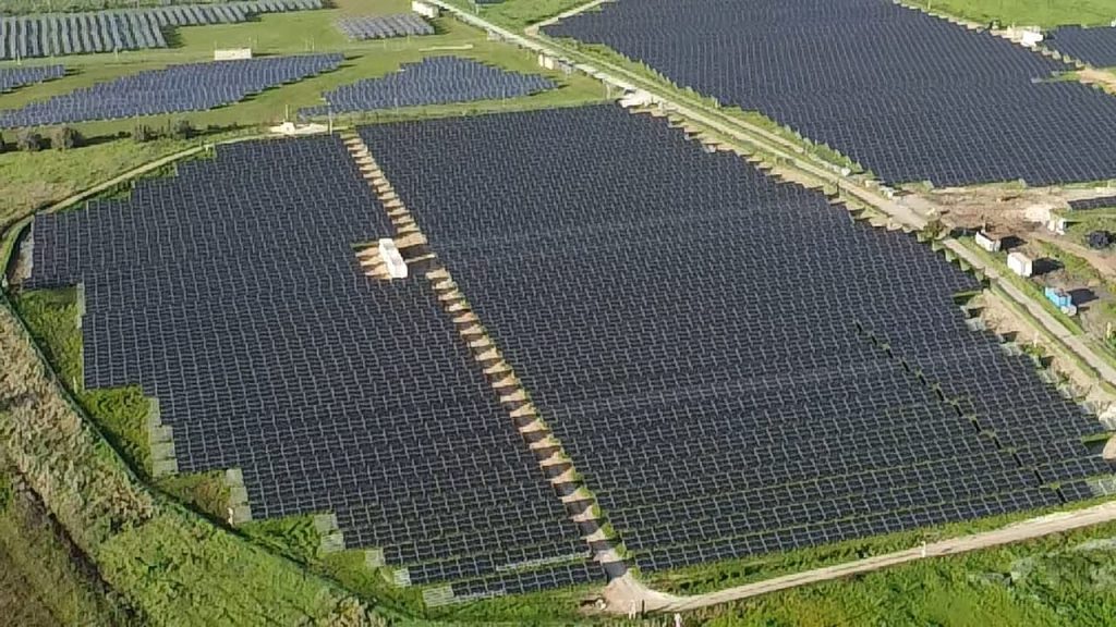 Campo fotovoltaico con pannelli solari installati a terra.